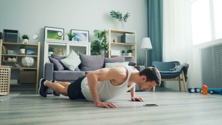 Man doet push-ups in een zonnige woonkamer thuis, illustratief voor korte krachttraining naast zittend werk